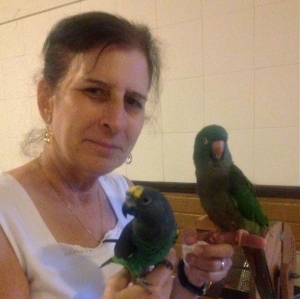 Joni holding Tango, her therapy bird (right), and Doreen's companion, Desi (left).